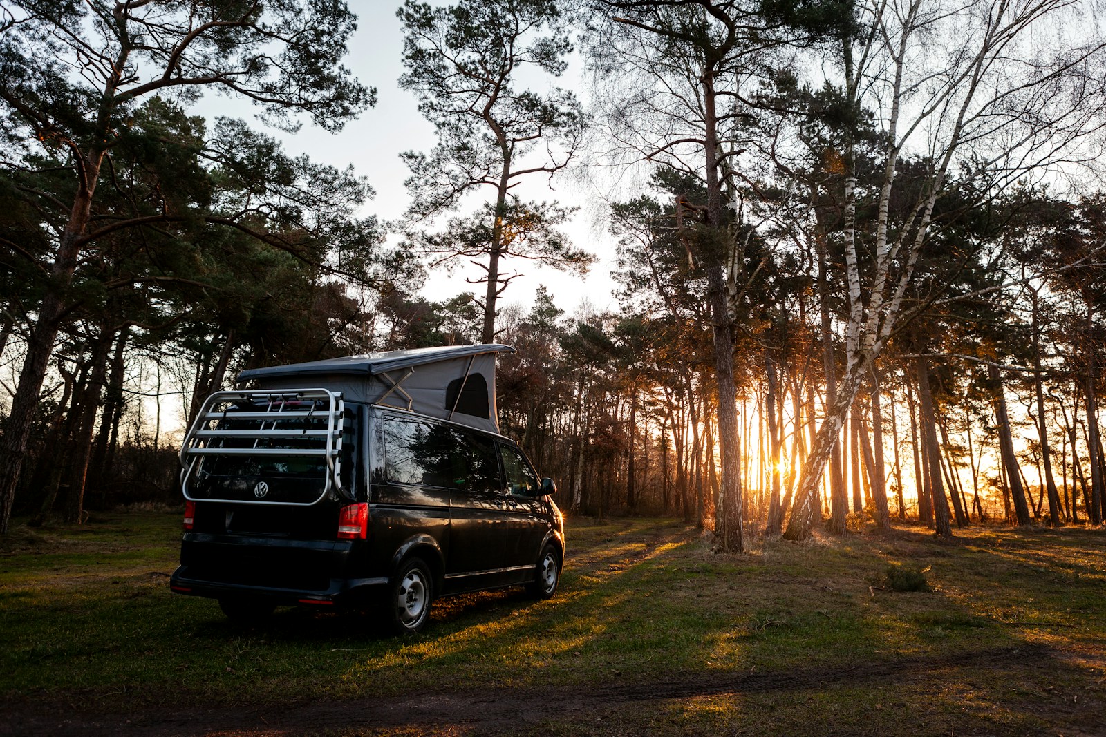 a van is parked in the middle of the woods